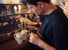 Barista working in coffee house making specialty coffee drinks